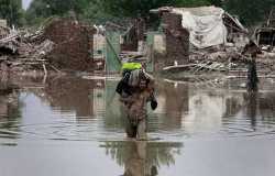 Ein Mann versucht, seine letzten Habseligkeiten aus seinem überfluteten Heim zu retten. Foto: Reuters/Faisal Mahmood